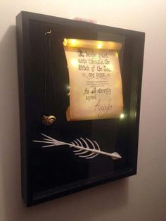 a framed piece of paper with an arrow on it and some lights in the background