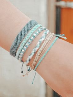 a woman's arm with several bracelets on it