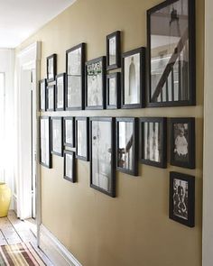 a wall with many framed pictures on it