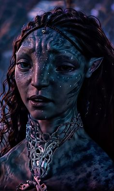 a close up of a woman with blue paint on her face and body, wearing silver jewelry