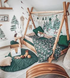 a bed with green sheets and pillows in a room decorated with christmas trees on the wall