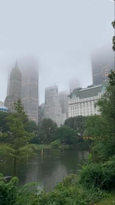 the city is surrounded by tall buildings and foggy skies, as well as trees