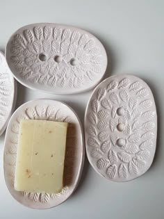 four white plates with different types of soap on them