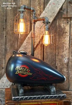 the harley davidson tank lamp is on top of a wooden crate with two lights attached to it