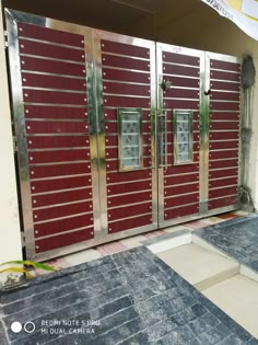 the entrance to a building with red metal doors and steps leading up to it's entry