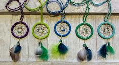 several different colored dream catchers hanging on a wall