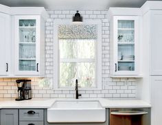 a kitchen with white cabinets and gray countertops is seen in this image from the front view