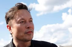 a close up of a person wearing a black shirt and looking off into the distance