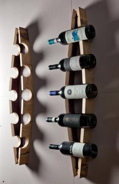 several wine bottles are lined up on wooden racks