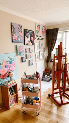 a living room filled with lots of art and decor on the wall next to a painting easel