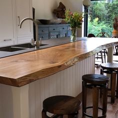 a kitchen with an island made out of wood and stools in front of it