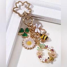 a bunch of charms that are sitting on a doorknott with flowers and bees