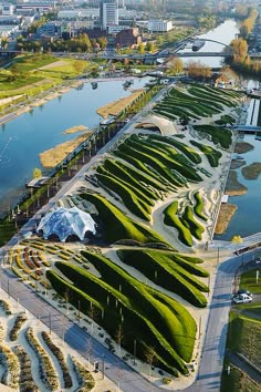 an aerial view of a park with lots of green plants on the ground and water in the background