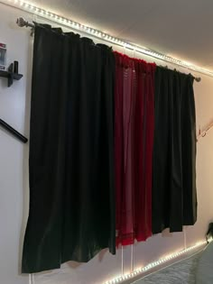 the curtains are hanging on the wall above the bed in the room with the lights