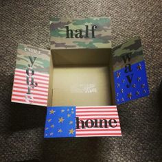 an open box with the word home painted on it, and two flags in different colors