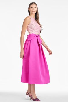 The Whitley skirt in cerise is the dream day-to-night, all-year-long skirt. This perennial silhouette is made more special with our signature pop of pink. At the waist a faux full bow-belt sash with stitched down belt both flatters and conceals. A side zip closure allows for a clean finish to this spectacular skirt. Details:Model is 5'10" wearing a size 2Full Length 52"35 1/2" Skirt Length100% PolyesterSide ZipperImportedStyle #F241S01-670 Elegant Pink Evening Skirt, Elegant Pink Prom Skirt, Elegant Pink Flared Dress, Chic Pink Skirt For Cocktail, Pink Midi Skirt For Evening, Formal Flared Pink Skirt, Pink Satin Skirt For Party, Pink Feminine Skirt For Formal Occasions, Formal Pink Pleated Skirt