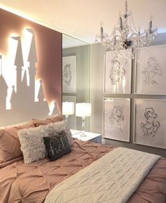 a bed sitting under a chandelier in a bedroom next to pictures on the wall