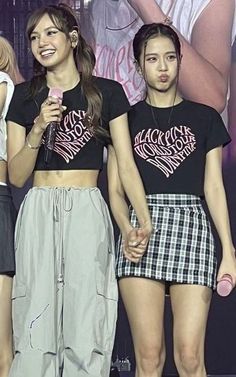 three girls standing on stage with microphones in their hands