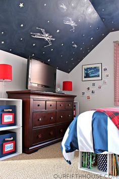 a bedroom decorated in blue and white with stars painted on the ceiling, bedding and dressers