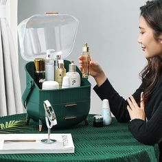 a woman is sitting at a table with her hand in the container and she is looking into it