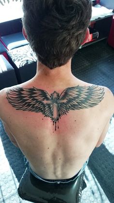 the back of a woman's neck with an eagle tattoo on her left shoulder