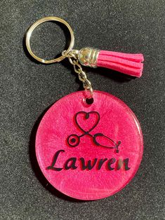 a pink keychain with the word lauren on it and a tassell