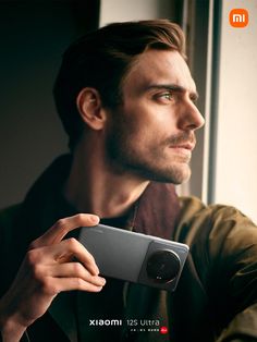 a man is holding up his camera in front of him and looking out the window