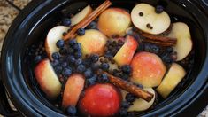 apples, blueberries and cinnamon sticks are in the crock pot