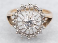 an antique diamond ring is shown on a white surface with the center setting surrounded by smaller diamonds