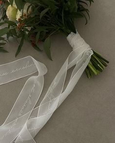 the bridal bouquet is laying on the floor next to it's wedding ribbon