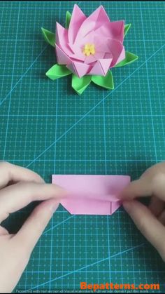 someone is making a flower out of origami paper and cutting it into smaller pieces