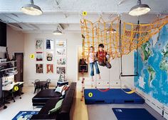 two children are playing in a play room with a map on the wall behind them