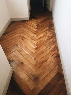 an empty room with wood flooring and white walls