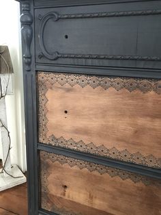 an old dresser has been painted black and is next to a lamp