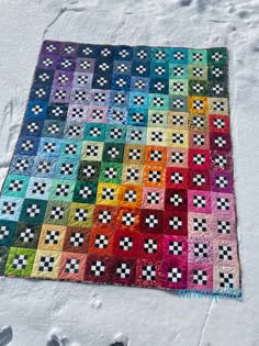 a colorful quilt is laying on the snow