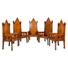 a set of six chairs with carved wooden back and arms, all facing different directions