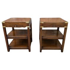 two wooden end tables with brass trimmings on each side and one drawer open