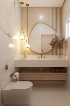 a white toilet sitting next to a bathroom sink under a round mirror in a bathroom