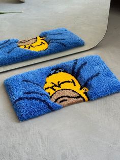 two blue towels with the image of a cartoon character on them are shown in front of a mirror