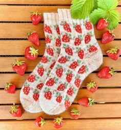 a pair of socks with strawberries on them sitting on top of a wooden table