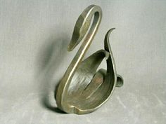 a metal swan sculpture sitting on top of a white table