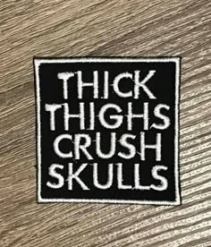 a sticker that says thick thighs, crush skulls on the side of a wooden surface