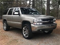 a silver truck is parked in the woods