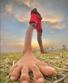 a person standing in the middle of a field with their hand on top of his head