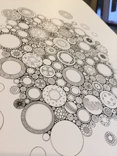 an artistic drawing is shown on top of a white sheet with circles and dots in the middle