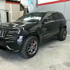 a black jeep is parked in a garage