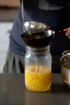 a person is stirring something in a jar