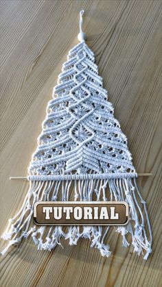 a crocheted christmas tree hanging on a wooden floor with the words,'how to