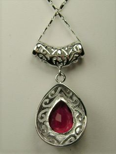 Simulated Red Ruby PendantBig Teardrop Design#P28This is a stunning Victorian inspired pendant necklace. This beautiful necklace is handcrafted from sterling silver. The flawless 6 carat man-made red ruby is a pear cut gemstone. Measurements are 16mm in length and 12mm in width. The 1.5mm sterling silver chain is 18" long (Chain may be different than pictured). The entire pendant is 1-11/16" long by 13/16" wide. The pendant & necklace are marked 925 for sterling silver. Notice the beautiful craf Fine Jewelry Ruby Teardrop, Red Gemstone Drop Jewelry, Red Drop Gemstone Jewelry, Ruby Drop Jewelry For Anniversary, Ruby Teardrop Fine Jewelry, Silver Pear-shaped Jewelry For Valentine's Day, Pear-shaped Silver Jewelry For Valentine's Day, Formal Ruby Drop Jewelry, Formal Ruby Drop Necklace