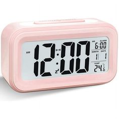 a pink alarm clock sitting on top of a table